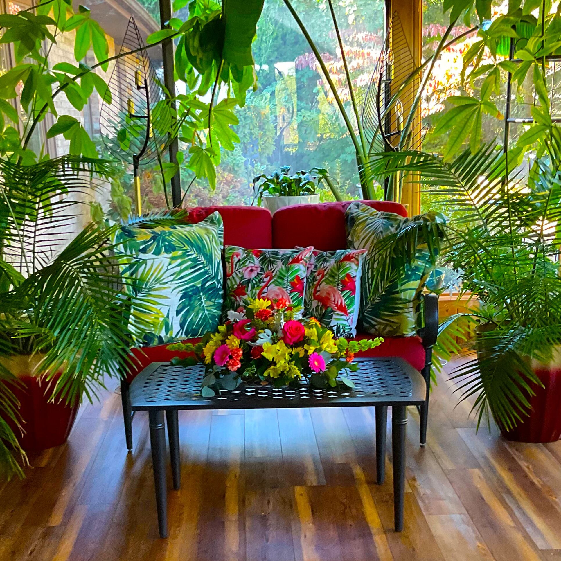 Sunroom bench with tropical pillows and flowers